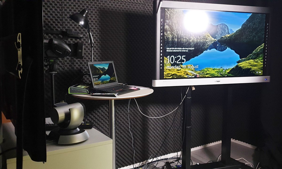 Et lydisoleret studie med to skærme, et kamera og en computer